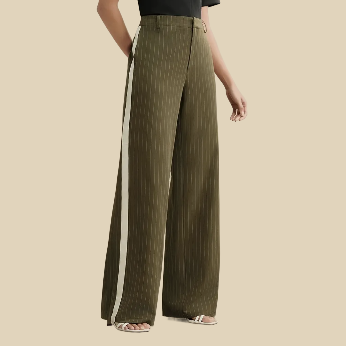 A person wearing olive green pinstriped wide-leg pants with a white stripe down the side.